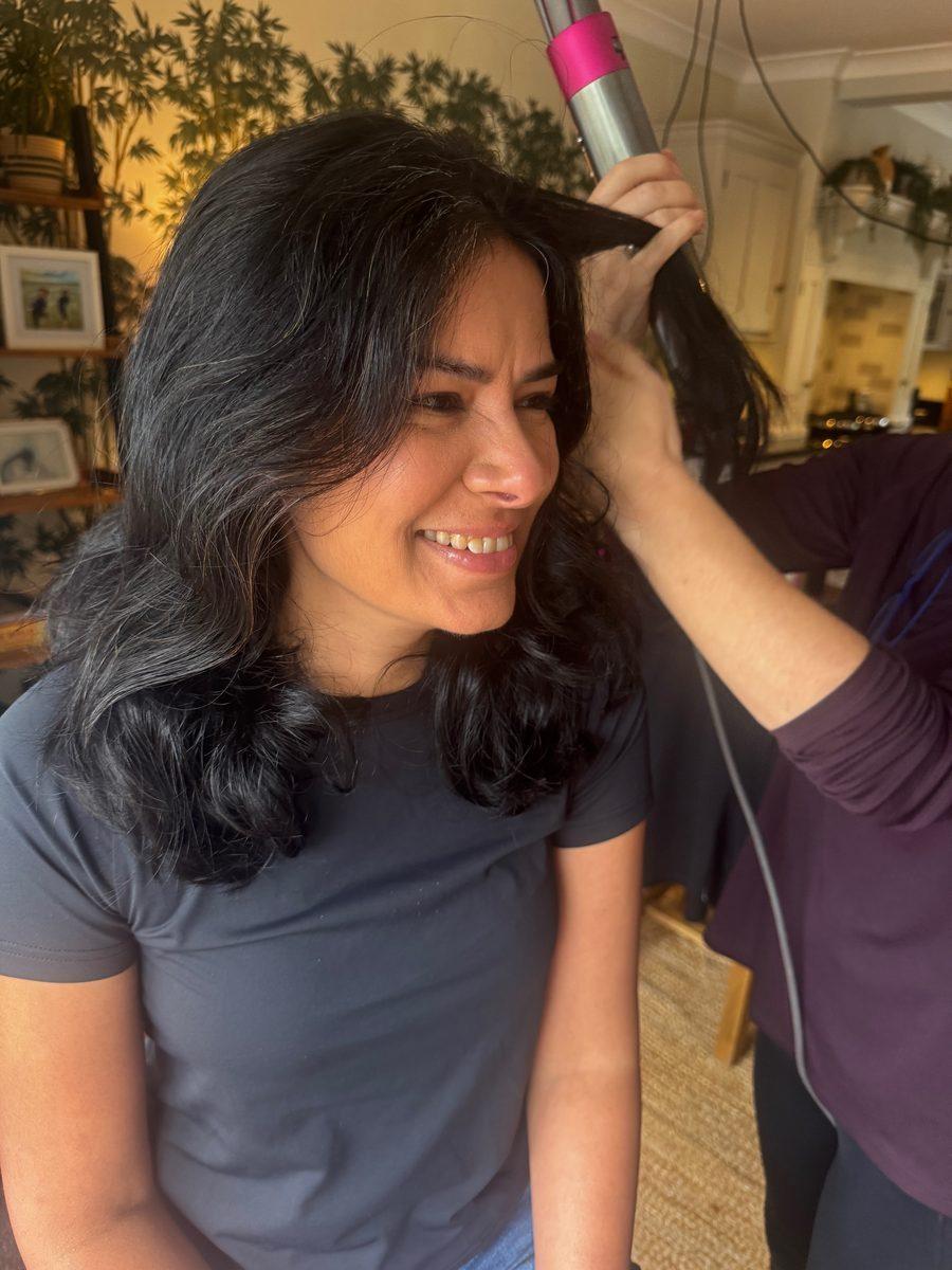 A friend laughing while her hair is dried before the shoot
