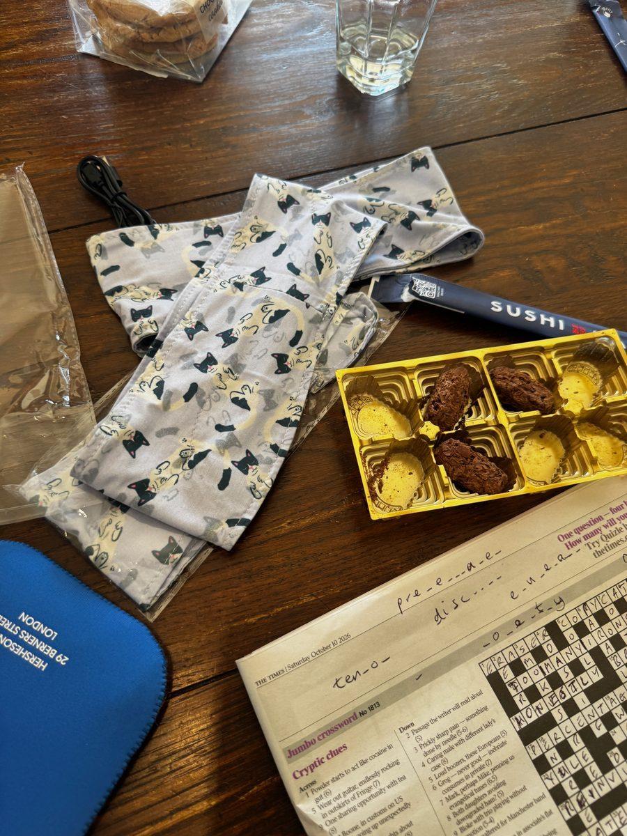 Sleep bands on a kitchen table next to a box of chocolates and a half-done crossword