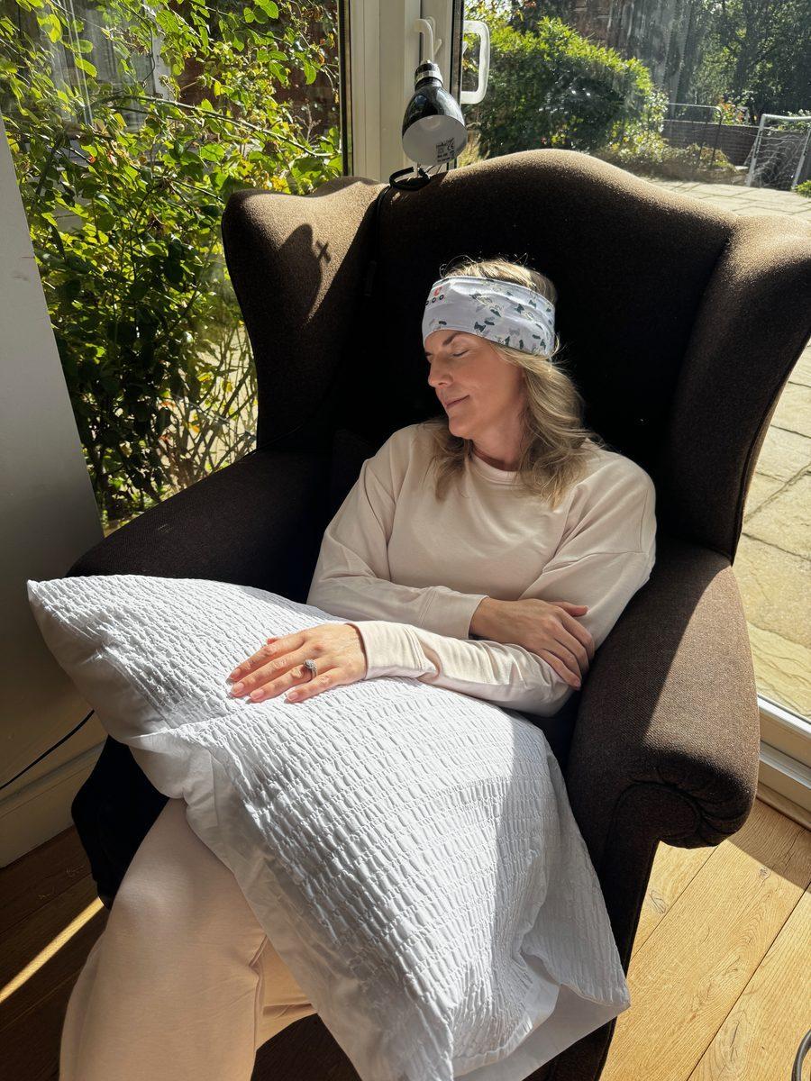 A friend napping in an armchair, wearing the sleep band