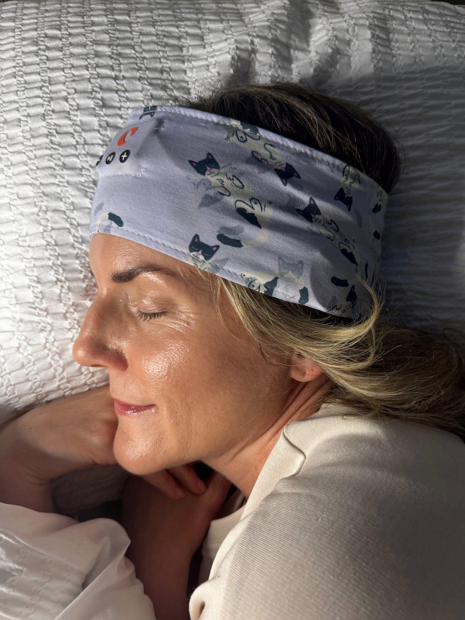 A woman asleep on her pillow wearing the Clementine sleep band
