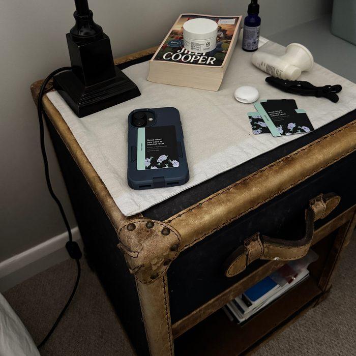 A bedside table with a phone and sleep ritual cards