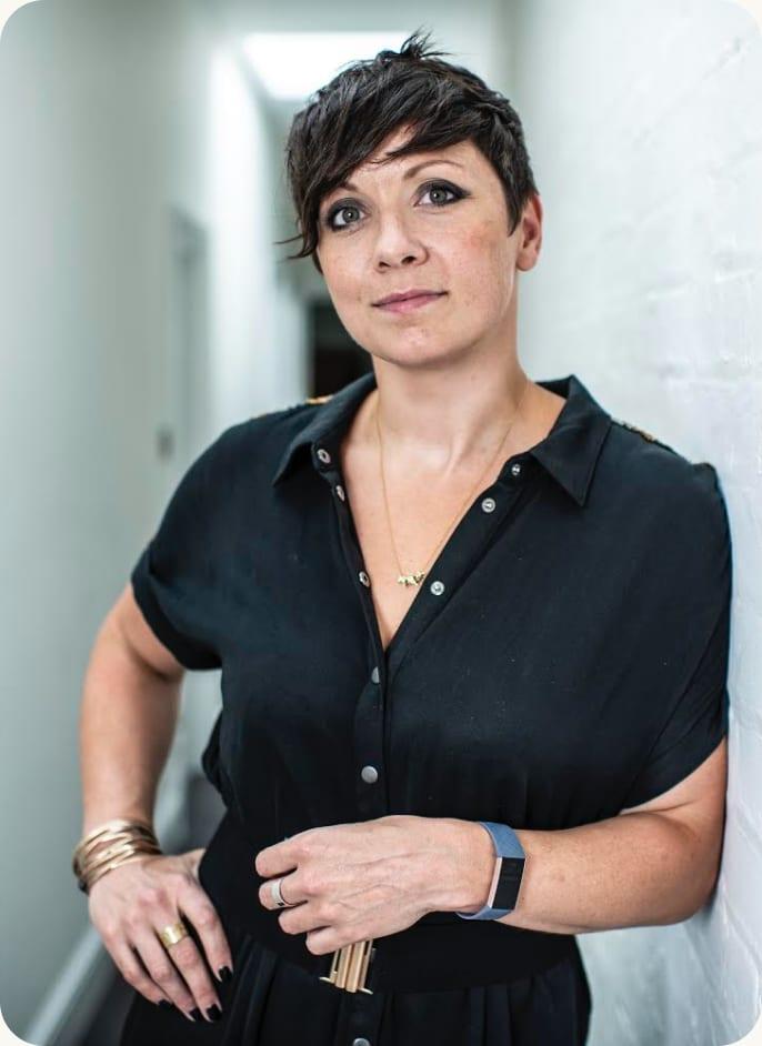 Hazel Gale, leaning against a wall in a black shirt